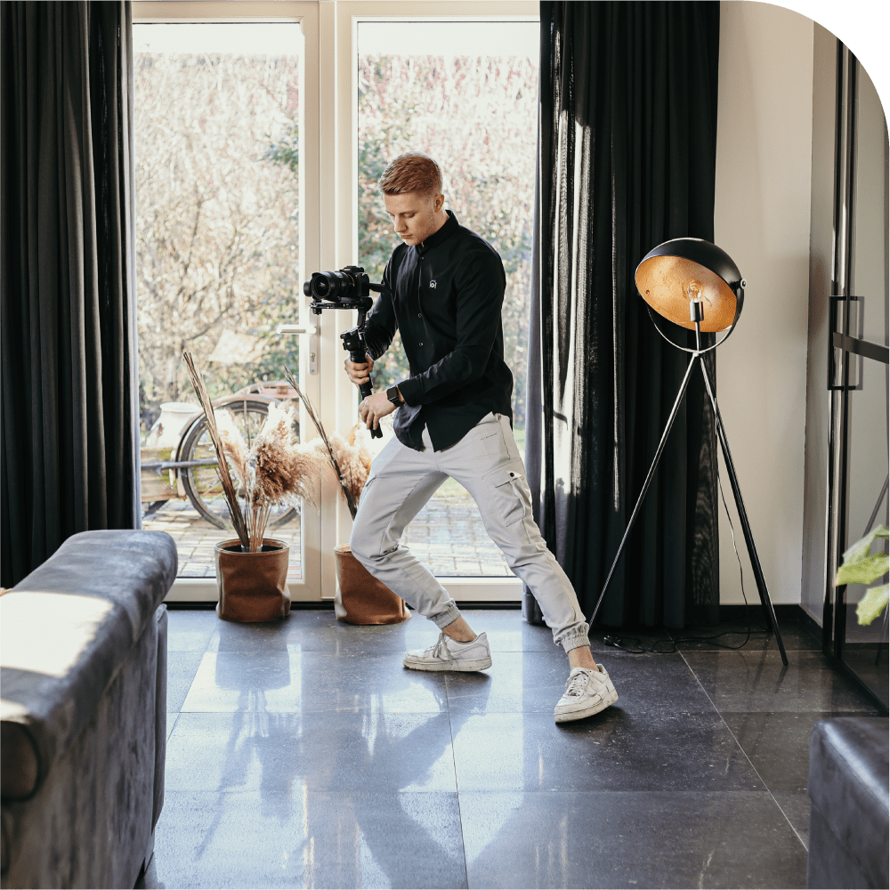 Sven van Wevisuals in een woonkamer met een camera in zijn handen.